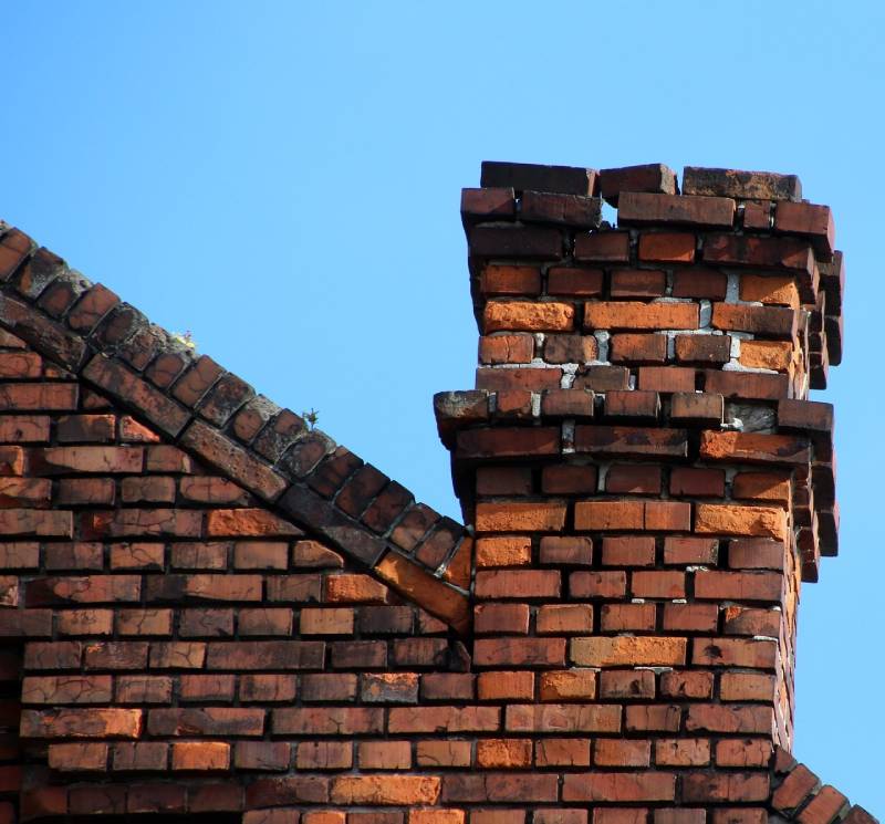 Damaged chimney on an Buena Park home showing cracks and missing mortar